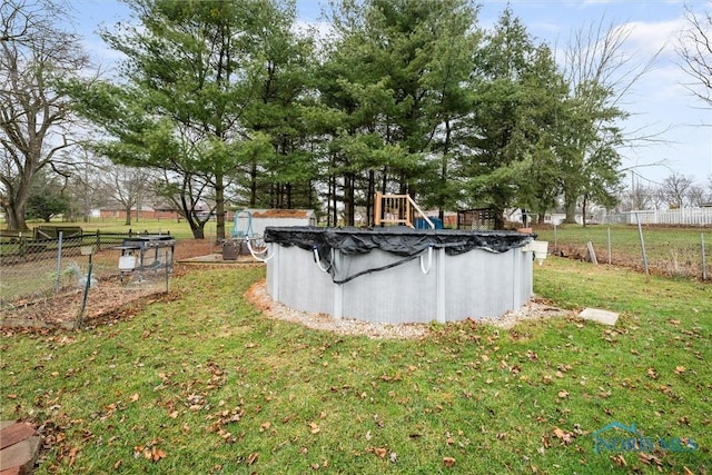 view of swimming pool with a yard