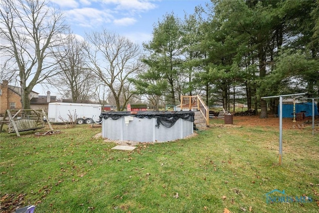 view of yard featuring a covered pool and a deck