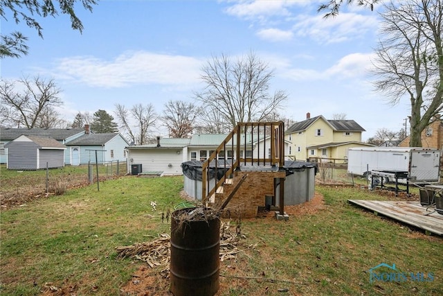 view of yard featuring central AC, a deck, and fence