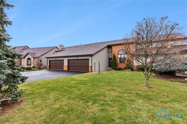 ranch-style house with a garage and a front lawn