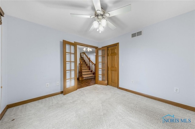 empty room with carpet flooring, ceiling fan, and french doors