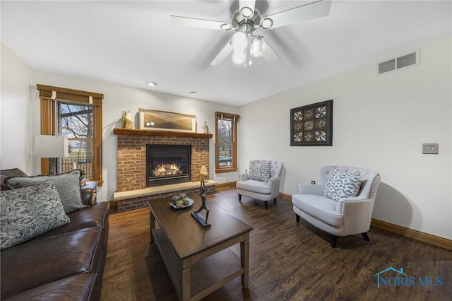 living room with a fireplace, ceiling fan, and dark hardwood / wood-style flooring