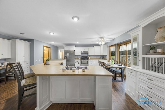 kitchen with range with electric stovetop, white cabinets, an island with sink, and stainless steel refrigerator with ice dispenser