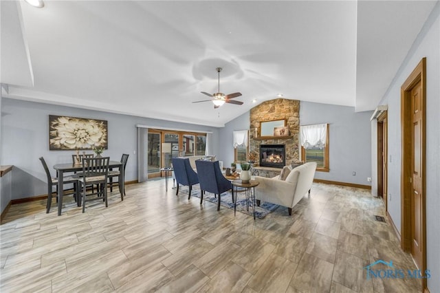 living room featuring ceiling fan, a fireplace, and lofted ceiling