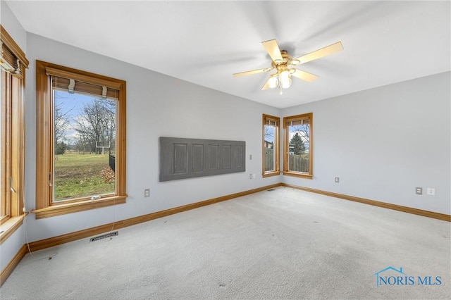 empty room with carpet flooring, plenty of natural light, and ceiling fan