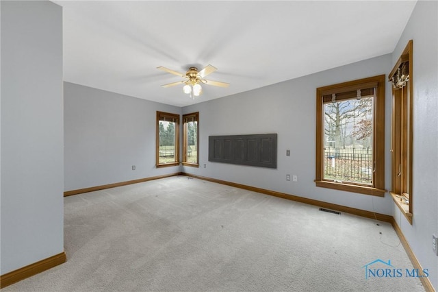 empty room featuring ceiling fan and light colored carpet