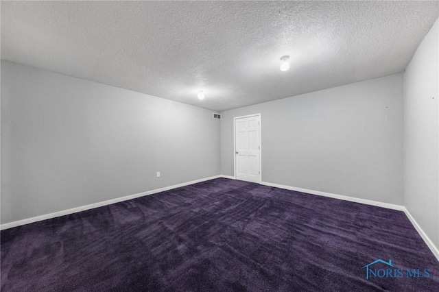 carpeted empty room featuring a textured ceiling