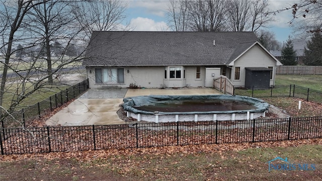 rear view of house with a covered pool