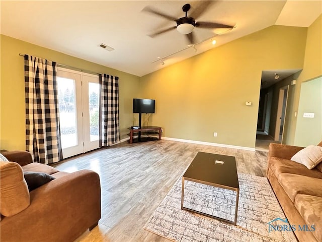 living room with ceiling fan, light hardwood / wood-style flooring, rail lighting, and lofted ceiling