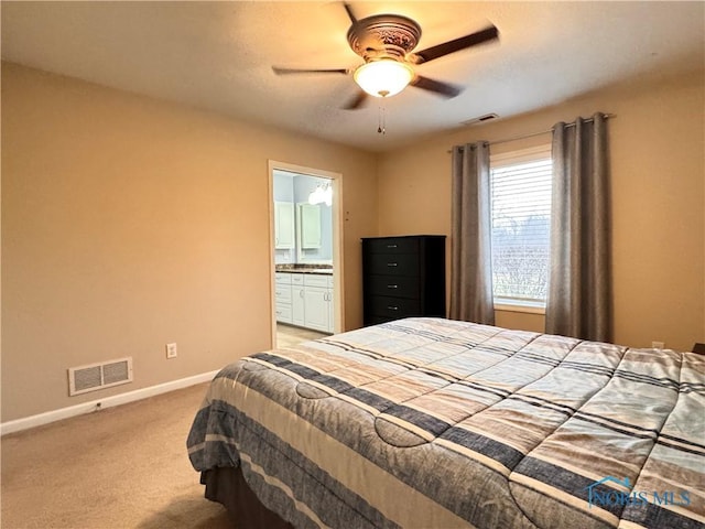 bedroom with ceiling fan, light carpet, and connected bathroom