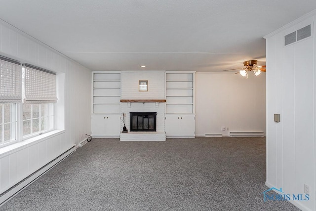 unfurnished living room with a brick fireplace, ceiling fan, dark carpet, and a baseboard radiator