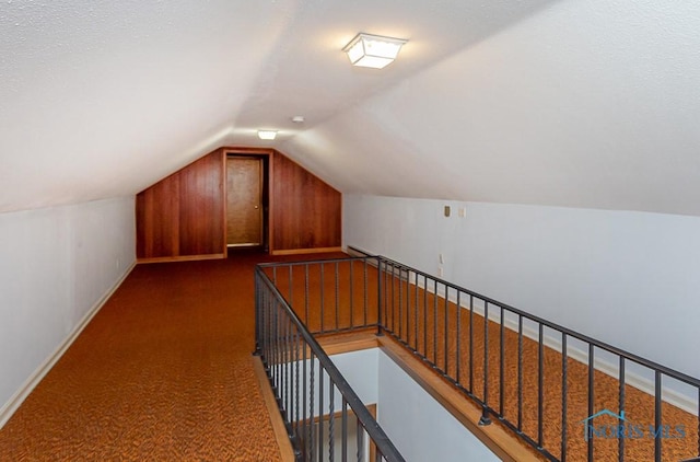 bonus room featuring lofted ceiling and dark colored carpet