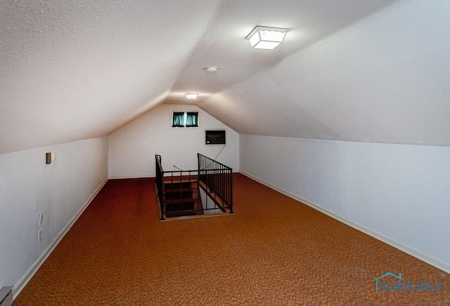 bonus room featuring lofted ceiling, a textured ceiling, baseboard heating, and carpet floors