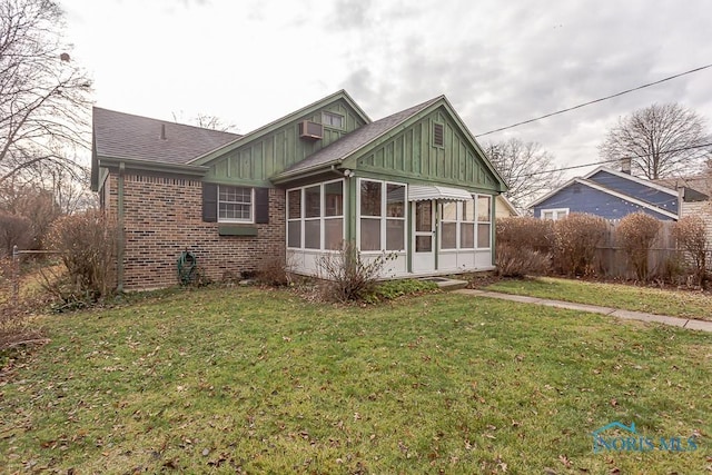 view of front of house with a front yard and a sunroom