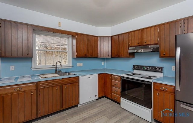 kitchen with sink, light hardwood / wood-style floors, and white appliances