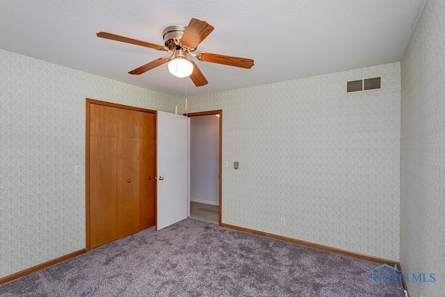 carpeted spare room featuring ceiling fan