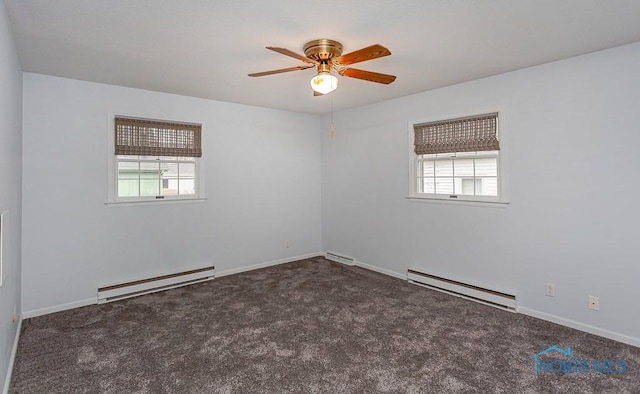 spare room featuring dark colored carpet, plenty of natural light, and baseboard heating