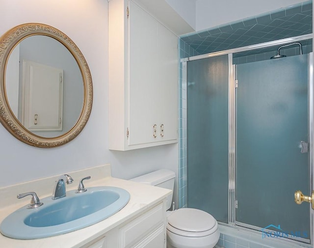 bathroom featuring vanity, toilet, and an enclosed shower