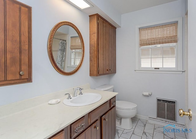 bathroom featuring vanity, heating unit, toilet, and walk in shower