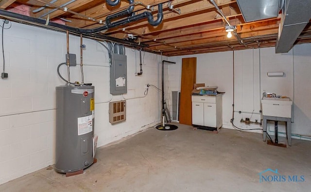 basement featuring electric panel and electric water heater