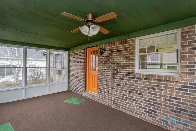 unfurnished sunroom with ceiling fan