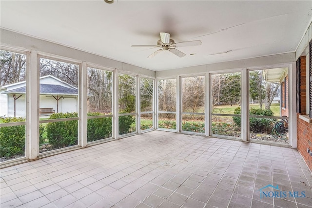 unfurnished sunroom featuring ceiling fan