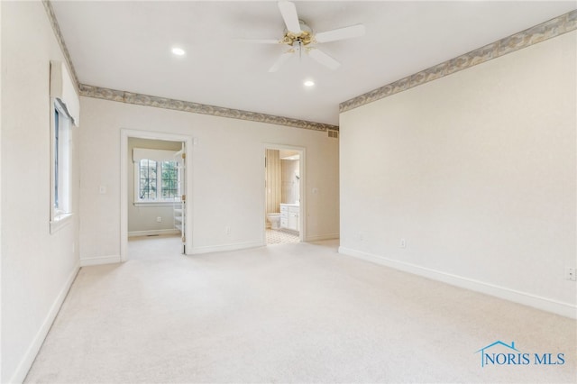 interior space featuring light carpet, ensuite bathroom, and ceiling fan