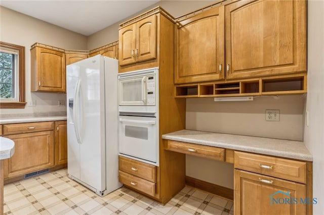 kitchen featuring built in desk and white appliances