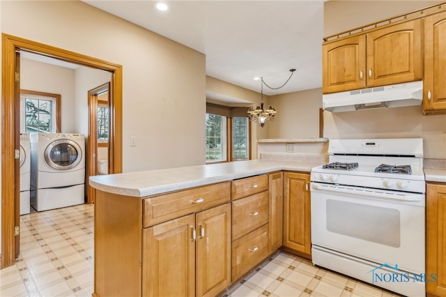 kitchen featuring an inviting chandelier, hanging light fixtures, washing machine and dryer, kitchen peninsula, and white range with gas cooktop