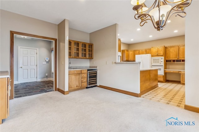 kitchen with beverage cooler, an inviting chandelier, pendant lighting, white appliances, and light carpet