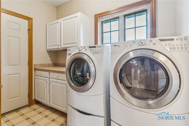 laundry area with cabinets and washer and clothes dryer