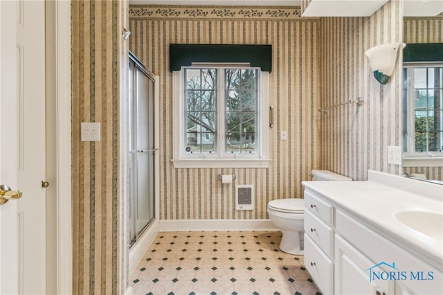 bathroom with toilet, plenty of natural light, vanity, and walk in shower