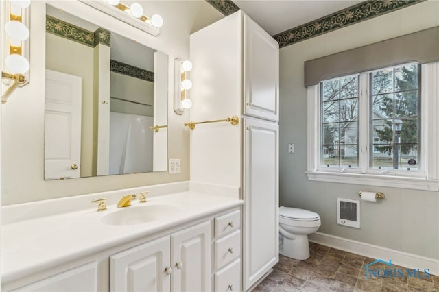 bathroom featuring vanity, heating unit, toilet, and walk in shower