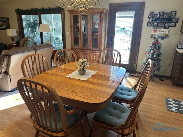 dining room with light hardwood / wood-style flooring and a notable chandelier