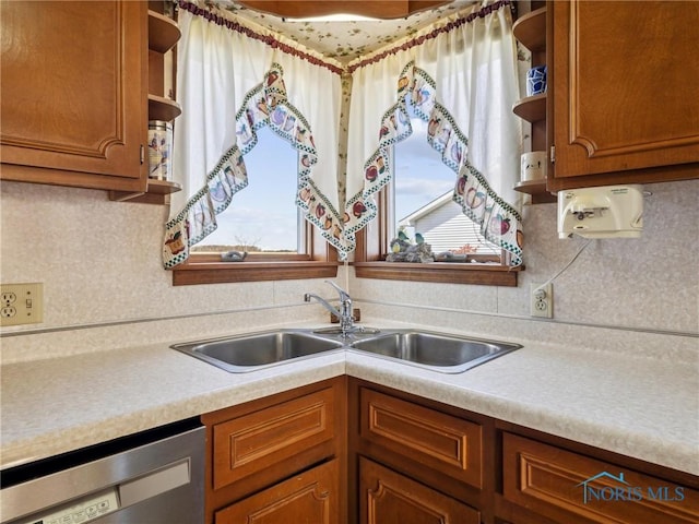 kitchen featuring decorative backsplash, dishwasher, and sink