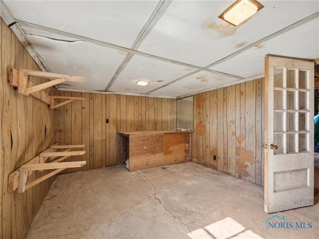 basement featuring wooden walls