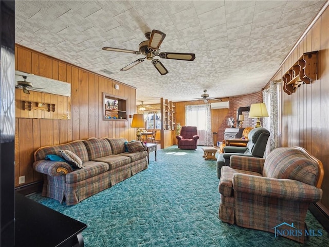 living room with carpet flooring, ceiling fan, wood walls, and a wall unit AC