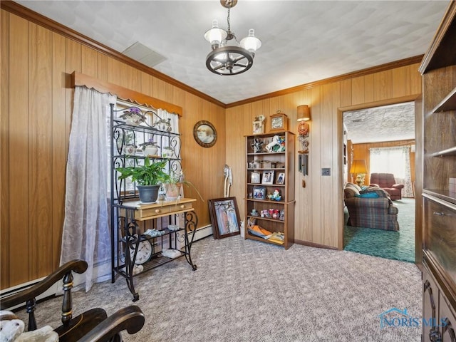 home office featuring carpet flooring, wood walls, crown molding, and an inviting chandelier