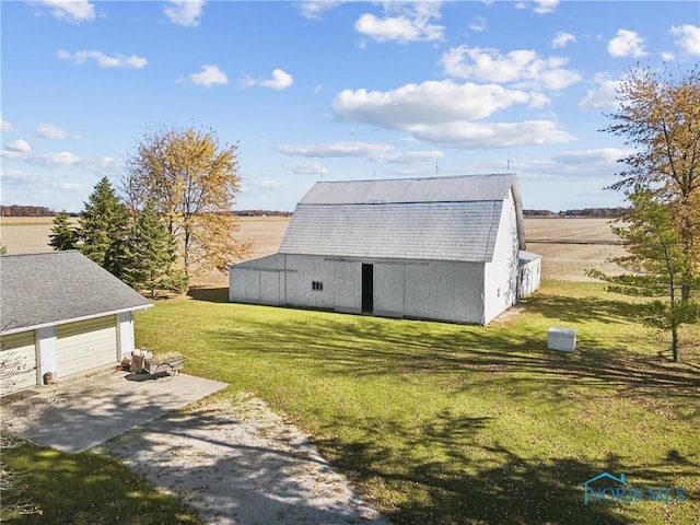 view of outdoor structure featuring a lawn and a rural view