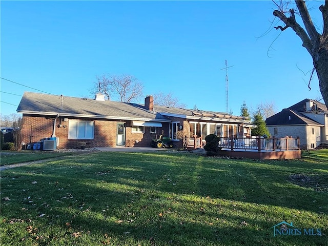 back of property featuring a lawn, a wooden deck, and central AC