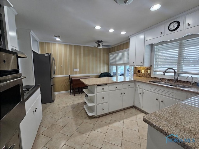 kitchen with white cabinetry, sink, appliances with stainless steel finishes, and ornamental molding