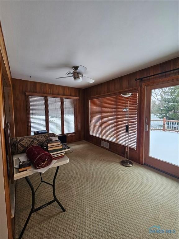 unfurnished sunroom featuring ceiling fan