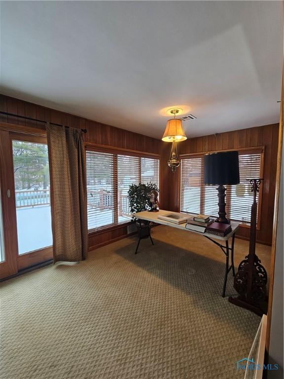 game room featuring carpet, a notable chandelier, and wood walls