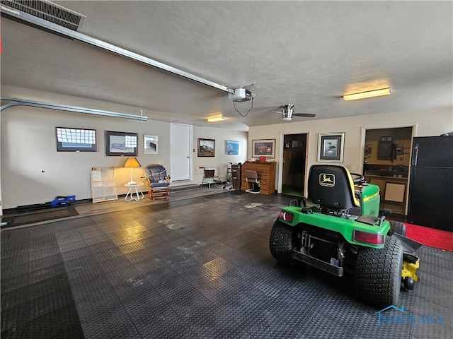 garage with black refrigerator and a garage door opener