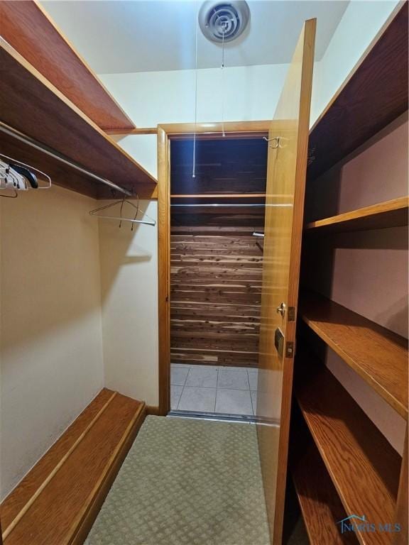 walk in closet with light tile patterned floors