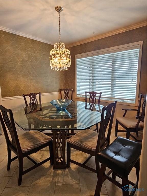 tiled dining area featuring a notable chandelier, plenty of natural light, and crown molding