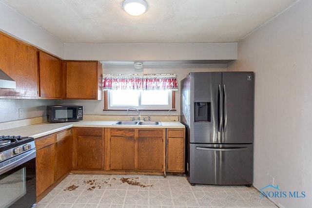 kitchen featuring light tile patterned floors, appliances with stainless steel finishes, and sink