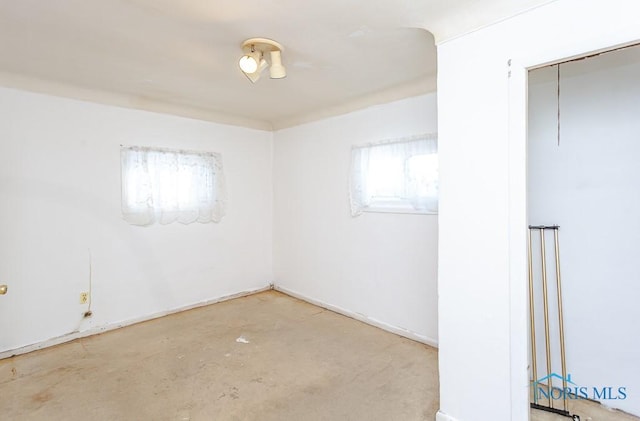 spare room featuring concrete floors and a healthy amount of sunlight