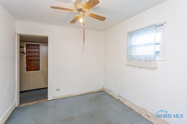 spare room featuring ceiling fan and concrete floors