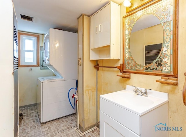 washroom featuring sink and stacked washer and dryer